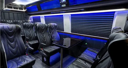 Front cabin of a Mercedes Sprinter showing the steering wheel, digital dashboard, and high-tech infotainment system