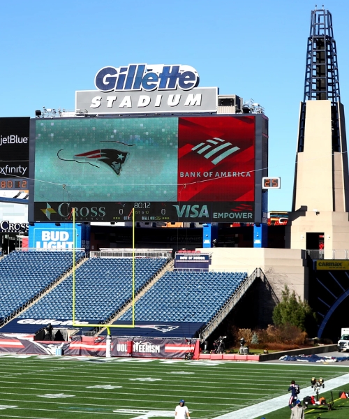 View of Gillette Stadium scoreboard and seating area during a football event, featuring the New England Patriots logo and stadium branding. View of Gillette Stadium scoreboard and seating area during a football event, featuring the New England Patriots logo and stadium branding.