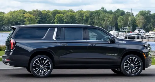 Side view of a black Chevrolet Suburban High Country executive SUV for group transportation