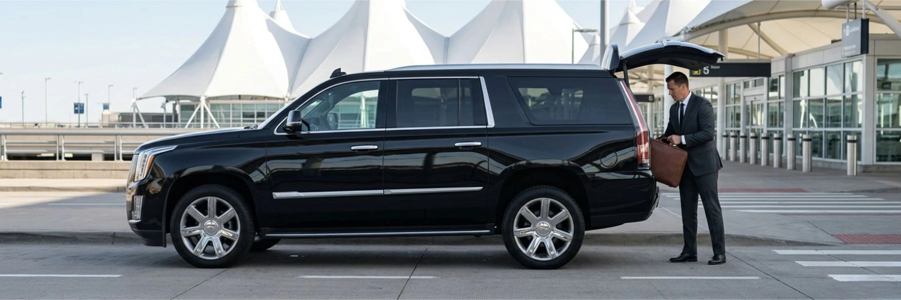 Black luxury SUV with chauffeur at airport